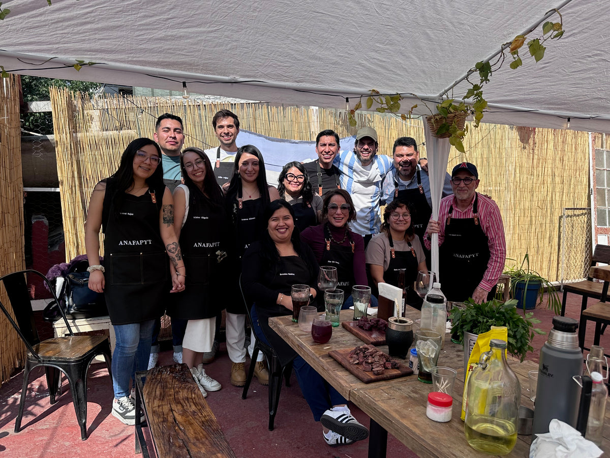 Grupo del taller de asado Asaditos Club con delantales